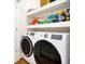 Laundry room with modern appliances, open shelving, and hardwood floors at 1701 A Palmetto Blvd, Edisto Island, SC 29438