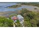 Stunning aerial view of marsh front home with dual balconies, mature trees, and grey brick driveway at 1801 Landfall Way, Seabrook Island, SC 29455