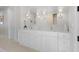 Bright bathroom with double vanity, marble countertops, decorative mirrors, and herringbone floors at 1801 Landfall Way, Seabrook Island, SC 29455