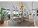Dining room with large windows, modern chandelier, and connection to the back porch at 1801 Landfall Way, Seabrook Island, SC 29455