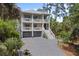 Charming multi-story home featuring dual balconies, a two-car garage, and an elegant gray brick driveway at 1801 Landfall Way, Seabrook Island, SC 29455