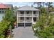 Charming multi-story home featuring dual balconies, a two-car garage, and an elegant gray brick driveway at 1801 Landfall Way, Seabrook Island, SC 29455