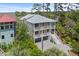 Charming multi-story home featuring dual balconies, a two-car garage, and an elegant gray brick driveway at 1801 Landfall Way, Seabrook Island, SC 29455