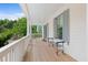 Inviting porch with light wood floors, white railings, blue shutters, and a view of the surrounding trees at 1801 Landfall Way, Seabrook Island, SC 29455