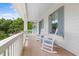 Charming porch with rocking chairs and a peaceful view of lush greenery at 1801 Landfall Way, Seabrook Island, SC 29455