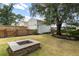 Backyard featuring a detached garage, a stone firepit, mature landscaping, and green grass at 1817 Towne St, Johns Island, SC 29455