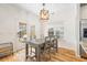 Cozy dining area with a wooden table, chairs, modern lighting, and view to the backyard patio at 1817 Towne St, Johns Island, SC 29455