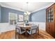 Bright dining room with a round wooden table, upholstered chairs, wainscoting, and modern chandelier at 1817 Towne St, Johns Island, SC 29455