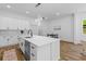 Bright kitchen has white cabinets, stainless steel appliances, an island with seating and views into an adjacent dining area at 1917 Jason St, North Charleston, SC 29406