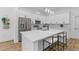 White kitchen offers an island with seating and sleek stainless steel appliances for a modern and stylish look at 1917 Jason St, North Charleston, SC 29406