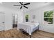 Bedroom featuring a ceiling fan, wood floors, and abundant natural light, adjacent to a modern bathroom at 1917 Jason St, North Charleston, SC 29406