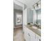 Bathroom featuring a white vanity with granite countertop, and neutral tiling with an open door at 2 Piedmont Ave # A, Charleston, SC 29403