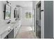 Modern bathroom with dual sinks, stylish mirrors, and a glass-enclosed shower at 2 Piedmont Ave # A, Charleston, SC 29403