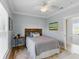Cozy bedroom with a checkered bedspread, hardwood floors, and an artistic wall painting and window at 2 Piedmont Ave # A, Charleston, SC 29403