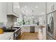 A full stainless appliance package is showcased in this bright kitchen with granite counters and stylish lighting at 2 Piedmont Ave # A, Charleston, SC 29403