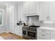 A classic range is featured in this kitchen with shaker cabinets, and granite counters with herringbone subway tile backsplash at 2 Piedmont Ave # A, Charleston, SC 29403