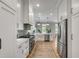 This modern kitchen is equipped with stainless steel appliances, white cabinets and a long runner on the light hardwood floor at 2 Piedmont Ave # A, Charleston, SC 29403
