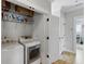 Laundry room with white appliances, wire shelving, and an open doorway, perfect for modern living at 2 Piedmont Ave # A, Charleston, SC 29403