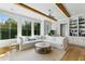 Bright living room boasts large windows, a ceiling fan, beautiful hardwood floors, and a comfortable oversized sectional couch at 2 Piedmont Ave # A, Charleston, SC 29403