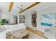 Cozy living room features exposed wooden beams, a ceiling fan, and stairs leading to the second floor at 2 Piedmont Ave # A, Charleston, SC 29403