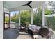 Relaxing screened-in porch featuring wicker furniture, pillows, and a view of the green surroundings at 2 Piedmont Ave # A, Charleston, SC 29403