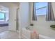 Bright bathroom showcases a soaking tub and shower with a large window at 215 Shortmarsh St, Summerville, SC 29486