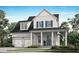 Charming two-story home with white siding, blue shutters, a welcoming front porch and a two car garage at 217 Clearpath Dr, Summerville, SC 29486