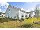 Spacious backyard showcasing green lawn, garden beds, and the home's light green siding at 220 Callibluff Dr, Summerville, SC 29486