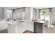 Open kitchen with white cabinets, quartz countertops, stainless steel appliances, and a view to a sunlit breakfast area at 220 Yalton St, Summerville, SC 29486