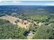 Aerial view of a community amidst dense greenery, featuring diverse buildings, roads and open fields at 225 Ridge Rd, Ridgeville, SC 29472