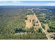 Aerial shot of a home site surrounded by verdant trees, a street, and a vibrant green meadow at 225 Ridge Rd, Ridgeville, SC 29472