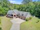 Aerial view of a home showcasing a three-car garage, spacious driveway, and beautifully landscaped grounds at 225 Ridge Rd, Ridgeville, SC 29472