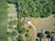 Aerial view of a well-maintained home with green lawn, a trampoline and surrounded by lush trees at 225 Ridge Rd, Ridgeville, SC 29472