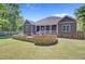 Spacious backyard with a stone patio, outdoor seating, and a well-manicured lawn at 225 Ridge Rd, Ridgeville, SC 29472