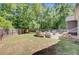 Large backyard with a fire pit, seating area, and wooded boundary at 225 Ridge Rd, Ridgeville, SC 29472