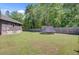A sprawling backyard with a trampoline, surrounded by lush greenery and a secure wooden fence at 225 Ridge Rd, Ridgeville, SC 29472
