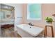 Bathroom featuring a freestanding tub and floral bedding in the adjacent bedroom at 225 Ridge Rd, Ridgeville, SC 29472