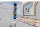 Bright bathroom featuring a tub with playful superhero-themed shower curtain and a granite vanity at 225 Ridge Rd, Ridgeville, SC 29472