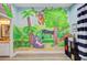 Unique bedroom featuring a colorful mural, neutral walls, and view to the bathroom at 225 Ridge Rd, Ridgeville, SC 29472