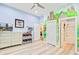 Bedroom with a hand-painted mural, gray wood floors, and a view to the bathroom at 225 Ridge Rd, Ridgeville, SC 29472