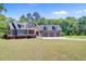 Well-maintained home with a three-car garage, lush landscaping, and a welcoming entrance at 225 Ridge Rd, Ridgeville, SC 29472