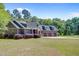 Beautiful home featuring a three-car garage, attractive landscaping, and a well-manicured lawn at 225 Ridge Rd, Ridgeville, SC 29472