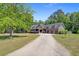 Charming home with a three-car garage, mature landscaping, and a long driveway at 225 Ridge Rd, Ridgeville, SC 29472