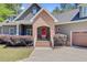 Beautiful home exterior featuring a brick entrance, red front door, and meticulous landscaping at 225 Ridge Rd, Ridgeville, SC 29472