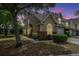 Beautiful dusk view of a tan townhouse with green grass and manicured landscaping at 247 Darcy Ave, Goose Creek, SC 29445