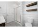 Bright bathroom featuring a glass shower, white door, shiplap accent wall, and patterned tile floor at 259 Weeping Cypress Dr, Moncks Corner, SC 29461