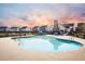 Community pool with a large pool deck, lounge chairs, and a cozy stone fireplace at 259 Weeping Cypress Dr, Moncks Corner, SC 29461