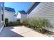 View of the side of a gray house featuring a concrete patio and landscaped area at 2909 Swamp Sparrow Cir, Johns Island, SC 29455