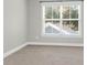 Empty bedroom with neutral carpet and gray walls, featuring a large window for natural light at 2909 Swamp Sparrow Cir, Johns Island, SC 29455