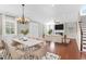 Open-concept dining and living room featuring a modern chandelier and hardwood floors at 2909 Swamp Sparrow Cir, Johns Island, SC 29455